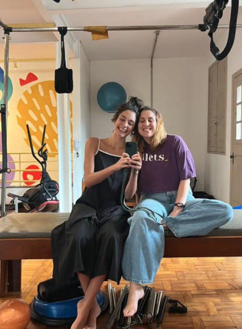 Camila com a Let, do Estúdio Pilets, abraçadas e sorrindo